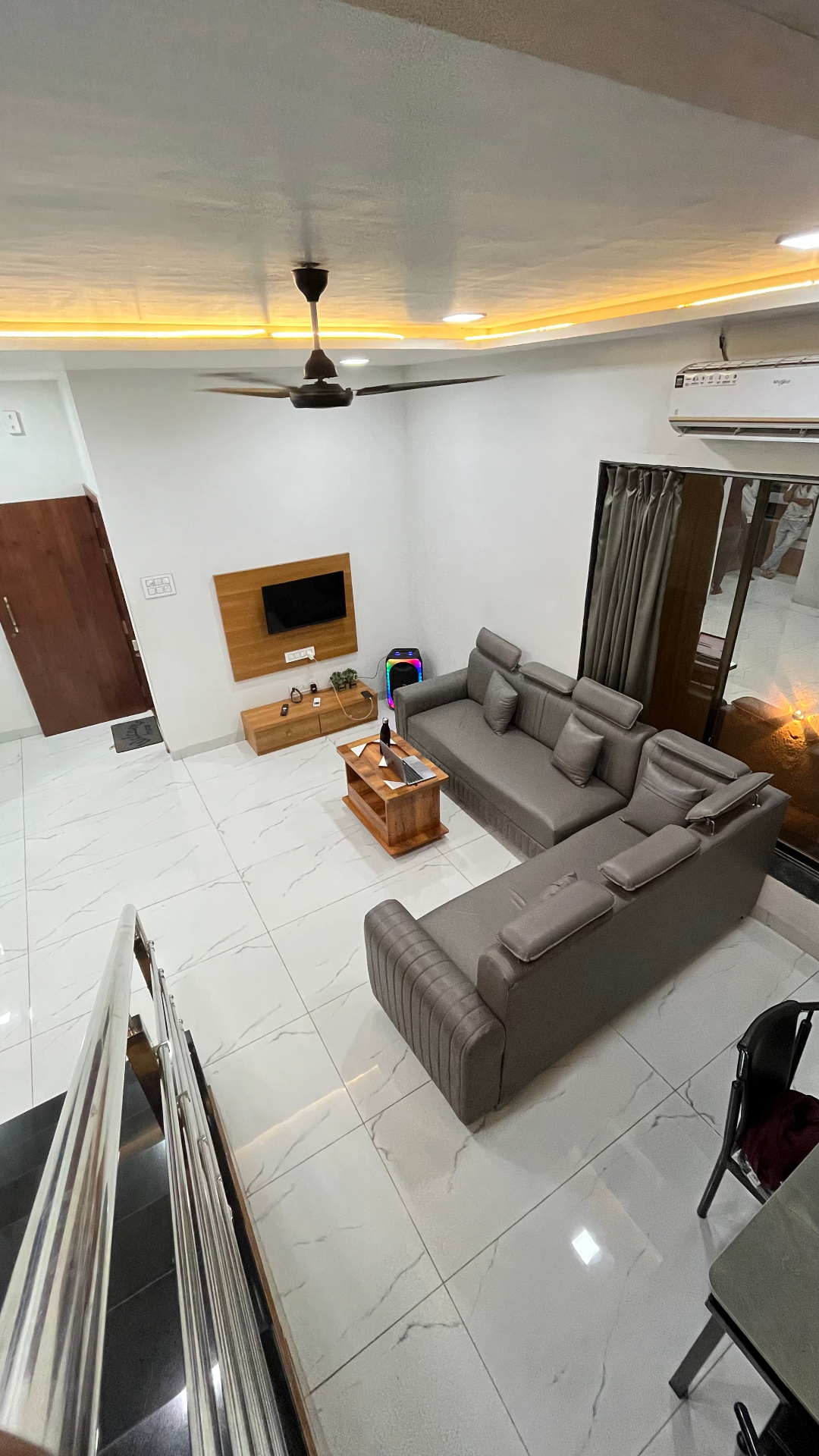 Saanjh villa living area with grey sofa, TV unit and ambient lighting